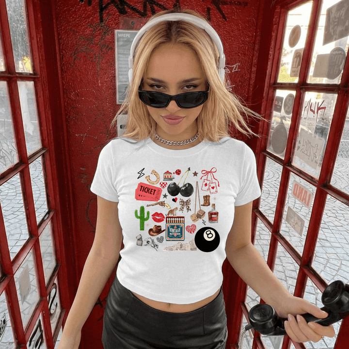 Woman wearing a white t-shirt with various graphics in a red phone booth.